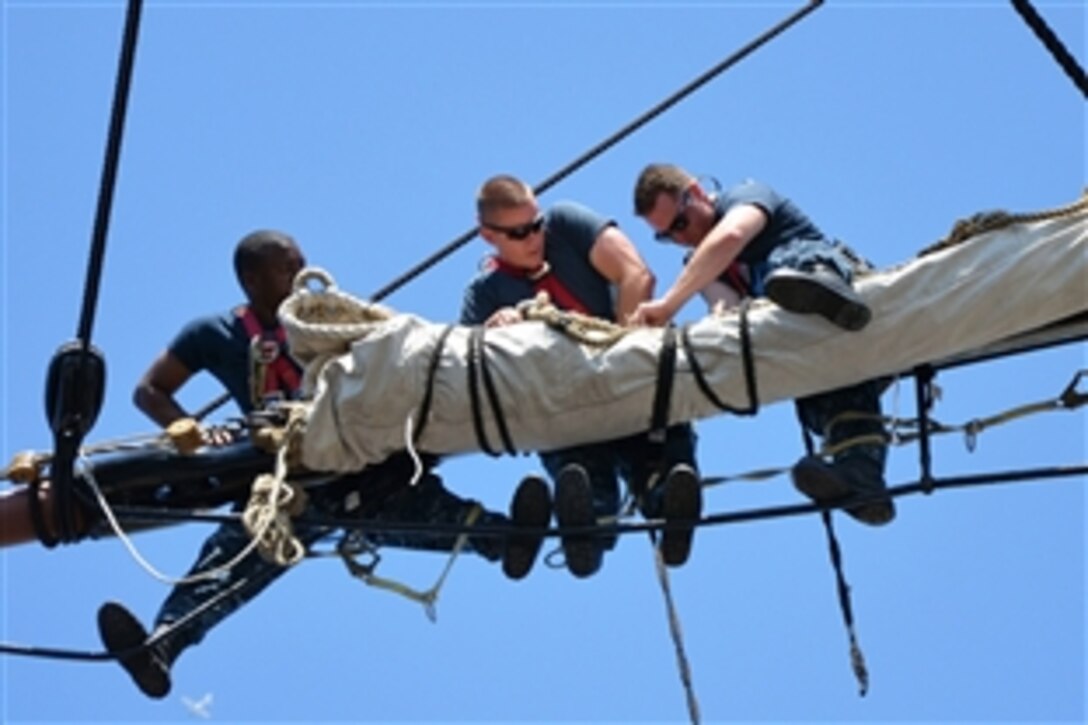 U.S. Navy sailors secure a sail to a yard on the mizzenmast of the USS Constitution in Charleston, Mass., June 17, 2013. The Constitution's sailors conduct training during spring and summer months to learn seamanship techniques used aboard "Old Ironsides" since the 1790s. 