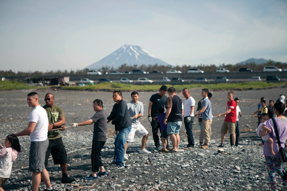 Japan Self-Defense Force members, Numazu residents, and U.S. Marines pull a rope during the annual Dragnet Festival June 1 at Numazu Beach, Japan. The event was centered on the Japanese tradition of dragnet fishing in which a massive net is towed into Suruga Bay and then dragged inland by hand. The festival brings JSDF members, prefectural residents and Marines together for a day of fun at the beach where they enjoyed fresh seafood, played games, and relaxed on the beach, according to Col. Blake M. Wilson, the commanding officer of Combined Arms Training Center Camp Fuji. 