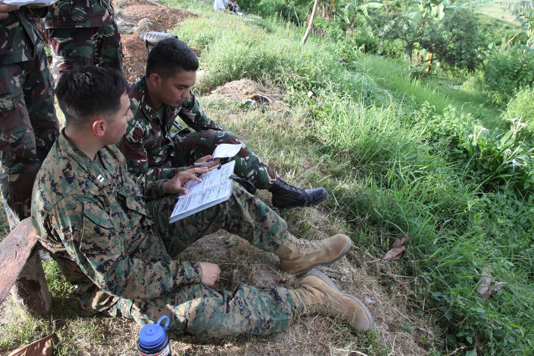 Capt. Danny Devito, a Marine All-Weather Fighter Attack Squadron 242 weapons systems officer and forward air controller, prepares the game plan with Philippine Air Force Airman 1st Class Edwin M. Osario, a joint terminal attack controller with 710th Special Operations Wing, while conducting airborne forward air control training during Exercise Haribon Tempest 2013 at Crow Valley Republic of the Philippines June 10.