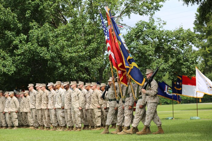Service members from 2nd Medical Battalion, 2nd Marine Logistics Group, stand at attention as the color guard retires the colors during a change of charge ceremony aboard Camp Lejeune, N.C., June 18, 2013. Master Chief Petty Officer Christopher L. Hill was relieved of his post during the ceremony, and Master Chief Petty Officer Michael J. Roberts was appointed the new command master chief petty officer for the battalion. (U.S. Marine Corps photo by Lance Cpl. Shawn Valosin)