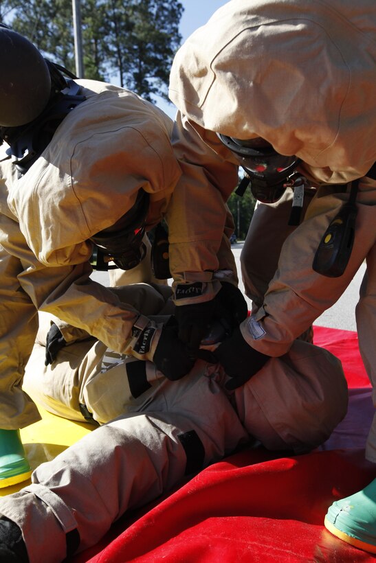 Chemical, biological, radiological and nuclear defense Marines defense Marines disassemble the class 2 ensemble of Lance Cpl. Tarra Melioris, a CBRN clerk, in the decontamination zone of a mock real-world terrorist laboratory at the CBRN facility June 15. Melioris was a mock heat casualty and had to be rapidly evacuated by her partner during the exercise. 