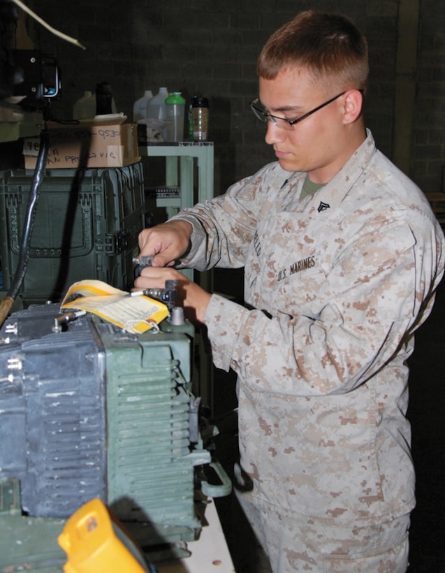 Cpl. Rick M. Bello, communications maintenance Marine, Marine Corps Forces Reserve, services a VRC110 radio during his two-week annual training at Marine Corps Logistics Command, June 11.  Bello was among 13 reservists from 6th Communications Battalion, Brooklyn, New York, to assist in the retrograde and reset of Operation Enduring Freedom communications equipment assets. 