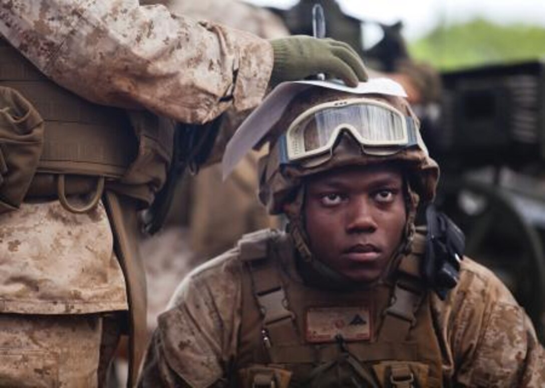 Lance Cpl. Erikthelbe Bronson, a cannoneer with Alpha Battery, 1st Battalion, 12th Marine Regiment, right, sits as Sgt. Shamar Jackson, a cannoneer with Alpha Battery, 1st Bn., 12th Marines, writes down the coordinates and number of rounds to be fired while receiving instructions for a fire mission given to gun A on the firing line during a three-day training exercise called Spartan Fury 13.3 at Schofield Barracks, June 11, 2013. Alpha Battery fired multiple 155 mm artillery shells from three M777 howitzers while Bravo Battery only fired from two. 
