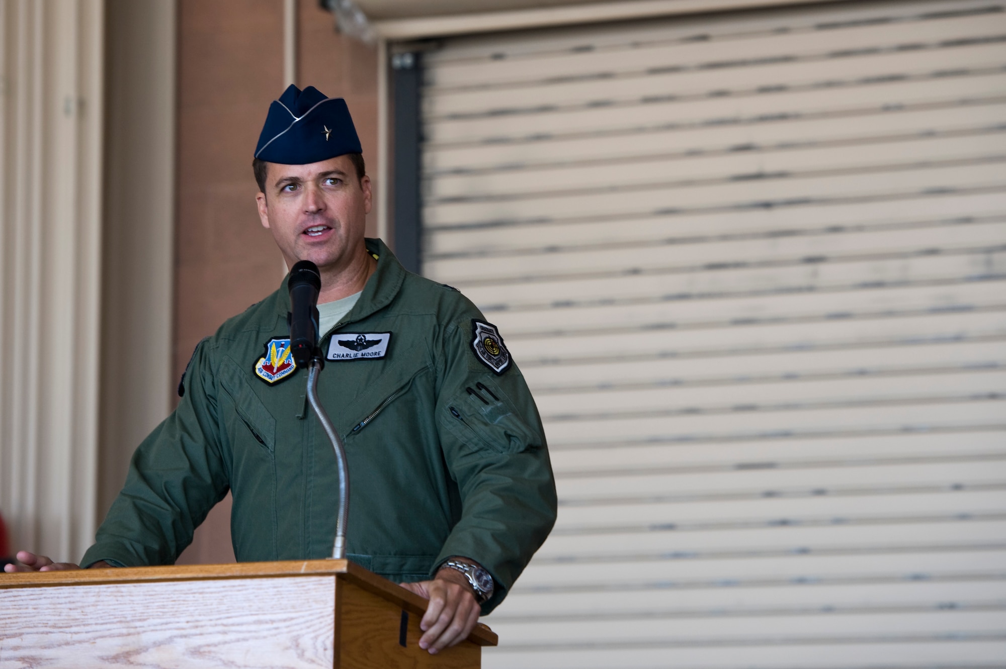 Brig. Gen. Charles Moore, 57th Wing commander, speaks to military members and civilians during the U.S. Air Force Weapons School change of command ceremony at the F-22 Raptor hangar June 17, 2013, at Nellis Air Force Base, Nev. Moore was the presiding official for the ceremony as Lt. Col. Adrian Spain assumed command from Col. Robert Garland, who is retiring. (U.S. Air Force photo by Airman 1st Class Christopher Tam)