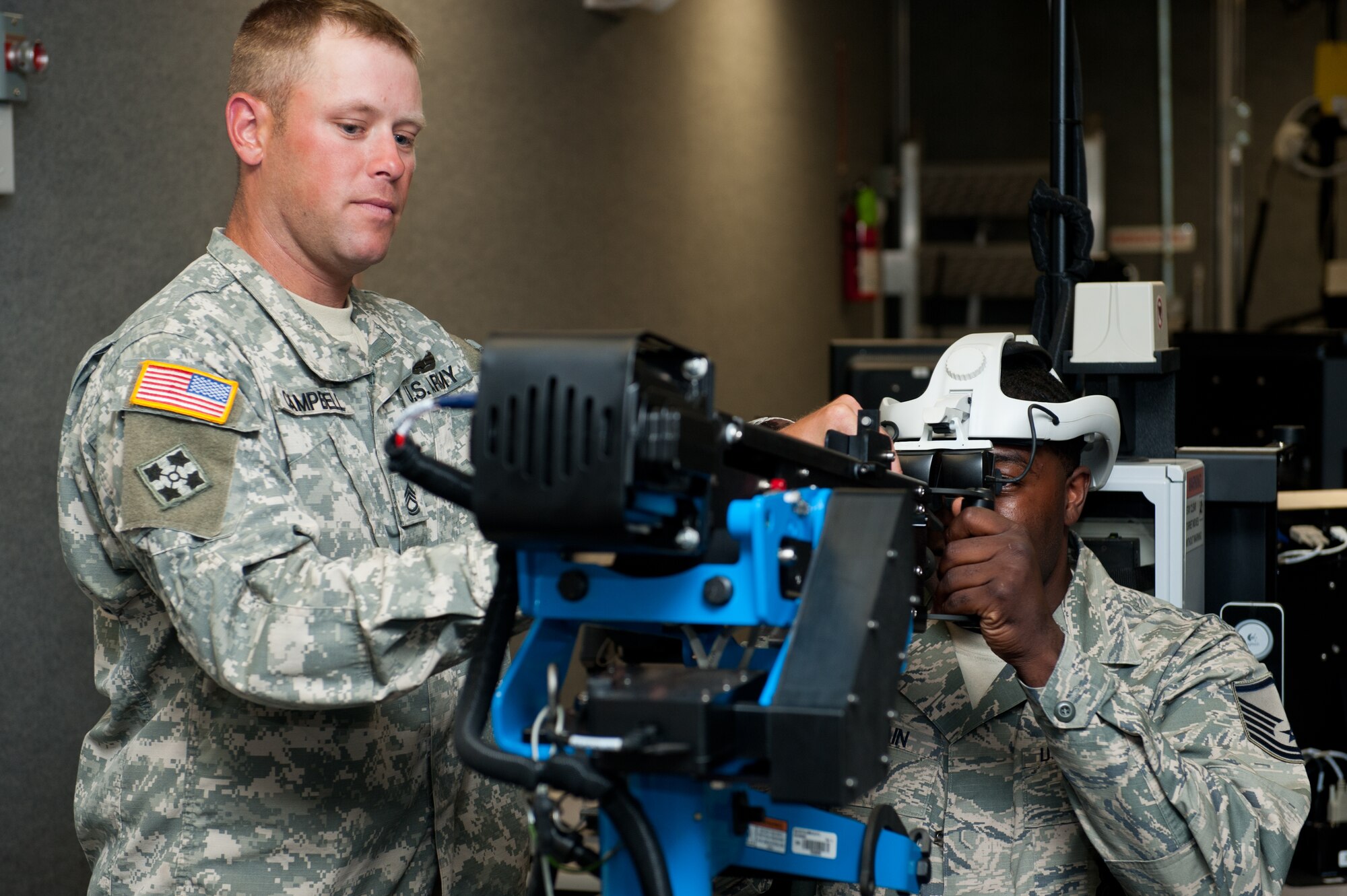 U.S. Army Sgt. 1st Class Tyler Campbell, South Dakota Army National Guard Training Center NCO in-charge, explains the gunner position of a virtual convoy simulator to Master Sgt. Charles Flanagain, 28th Bomb Wing Inspector General specialist, during the Golden Coyote exercise at Camp Rapid, S.D., June 18, 2013. The simulator is used to train military members on various combat scenarios they may encounter during convoy operations while deployed. (U.S. Air Force photo by Senior Airman Kate Maurer/Released)
