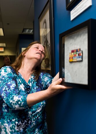 Mary Ellen Boyd, daughter of the late Col. John R. Boyd, hangs her father’s ribbon rack on the wall of Boyd Hall during a re-dedication ceremony June 14, 2013, at Nellis Air Force Base, Nev. Boyd was a senior pilot with more than 2,100 hours in the F-86 Sabre and the F-100 Super Sabre. Boyd received the Air Force Systems Command Scientific Achievement Award, the USAF Research and Development Award, the Air Force Association Citation of Honor, the Arnold Air Society Hoyt S. Vandenberg Award, and the Dr. Harold Brown Award for his work on energy-maneuverability, fighter design, and air-to-air tactics. (U.S. Air Force Photo by Airman 1st Class Jason Couillard)