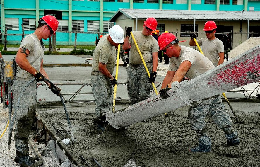 U.S. Air Force Airman 1st Class Rhett Buttleman (left), 7th Logistics Readiness Squadron (LRS), assists the 823rd RED HORSE Squadron pouring concrete in support of Operation New Horizons in Belize. Along with U.S. Air Force Staff Sgt. Donald King, 7th LRS, the two Dyess Airmen joined more than 90 RED HORSE Airmen to support numerous community projects in the area. From March – May 2013, Buttleman and King took part in constructing schools, renovating outdated playground equipment and built new basketball courts. In total, the team built four schools, each accommodating up to 500 students. (Courtesy photo)