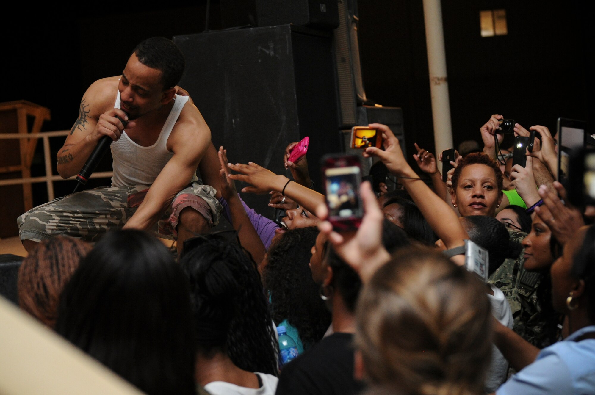 J. Holiday, a rhythm and blues vocalist, performs for service members in Memorial Plaza at the 379th Air Expeditionary Wing in Southwest Asia, June 18, 2013. The performance was followed by a meet and greet where service members were given the opportunity to take photos with the artist. (U.S. Air Force photo/Senior Airman Bahja J. Jones)