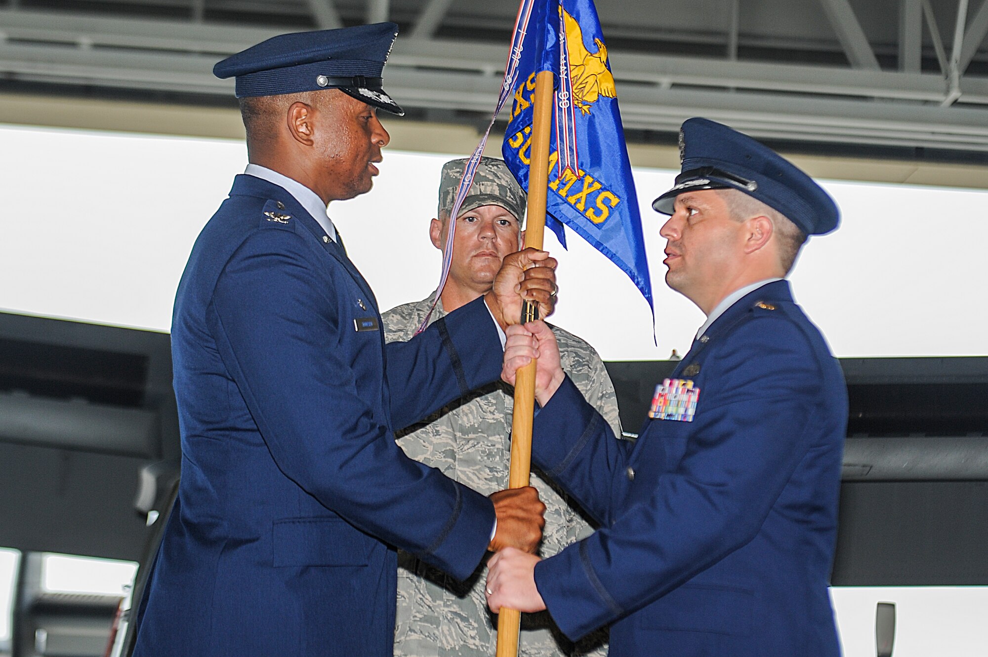Col. Kevin Howard, 1st Special Operations Maintenance Group commander (left), passes the 801st Special Operations Aircraft Maintenance Squadron guidon to Maj. Jeffrey Johns during a change of command ceremony at the Freedom Hangar on Hurlburt Field, Fla., June 17, 2013. Johns joins Team Hurlburt after graduating Command and Staff College at Marine Corps University, Quantico, Va. (U.S. Air Force photo/Airman 1st Class Christopher Callaway) 
