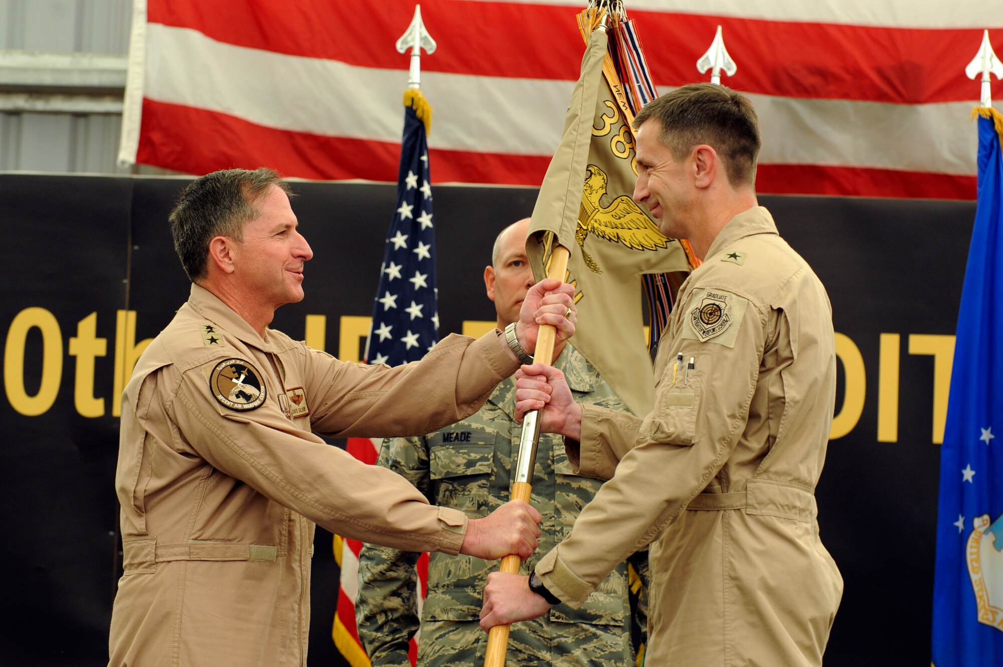 U.S Air Force Lt. Gen. David Goldfein, U.S. Air Forces Central commander, passes the 380th Air Expeditionary Wing guide-on to U.S. Air Force Brig. Gen. Kevin Schneider, 380th AEW commander, during the wing change of command ceremony at an undisclosed location in Southwest Asia June 20, 2013. The passing of the guide-on signifies the assumption of command. (U.S. Air Force photo by Staff Sgt. Joshua J. Garcia) 