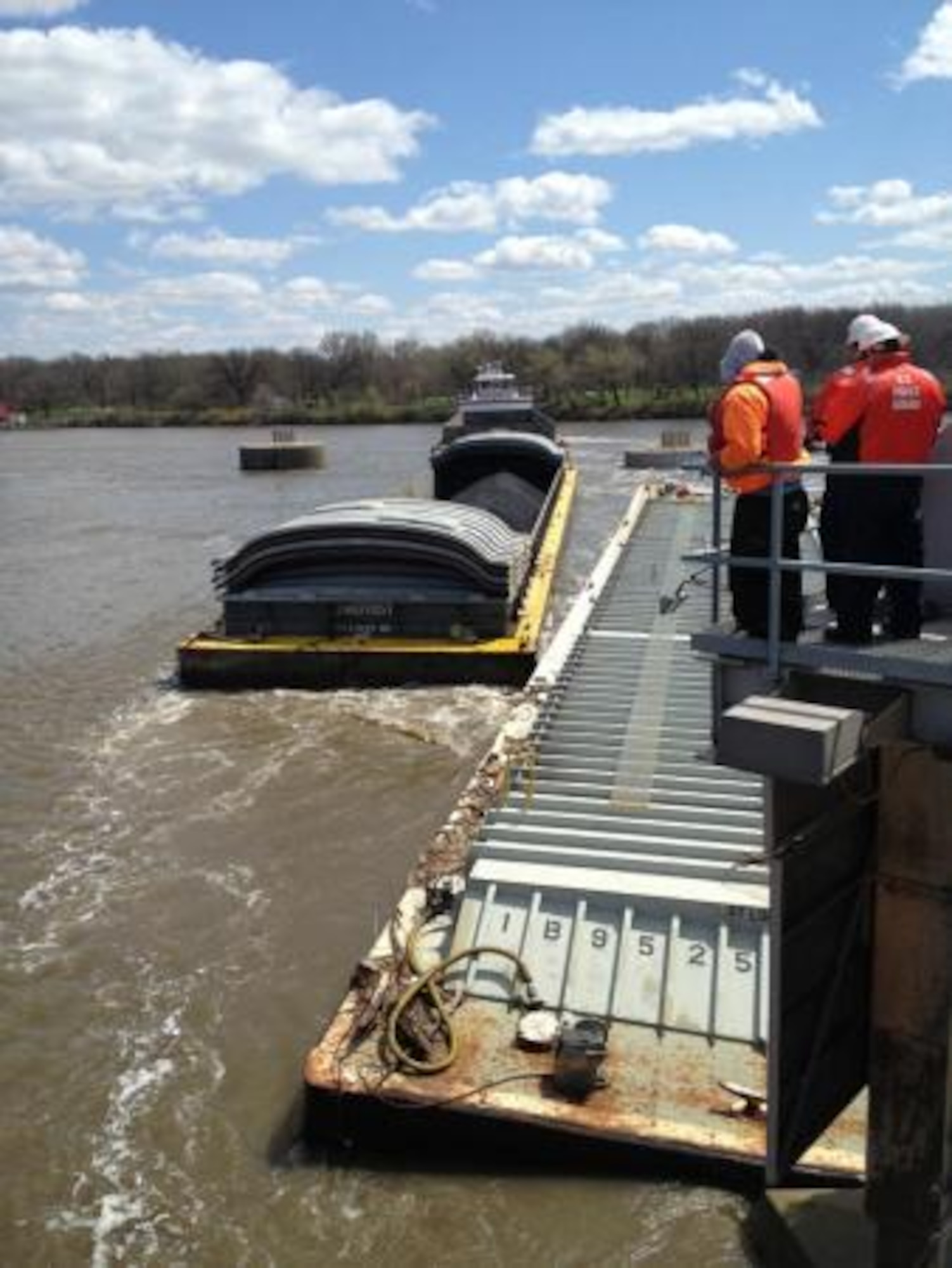 Coast Guard members watch as a barge is removed from near the Marseilles Dam June 12, 2013, in Marseilles, Ill. Three barges were removed during continued salvage operations. (U.S. Coast Guard photo by Lt. Cmdr. David Reinhard/Released)
