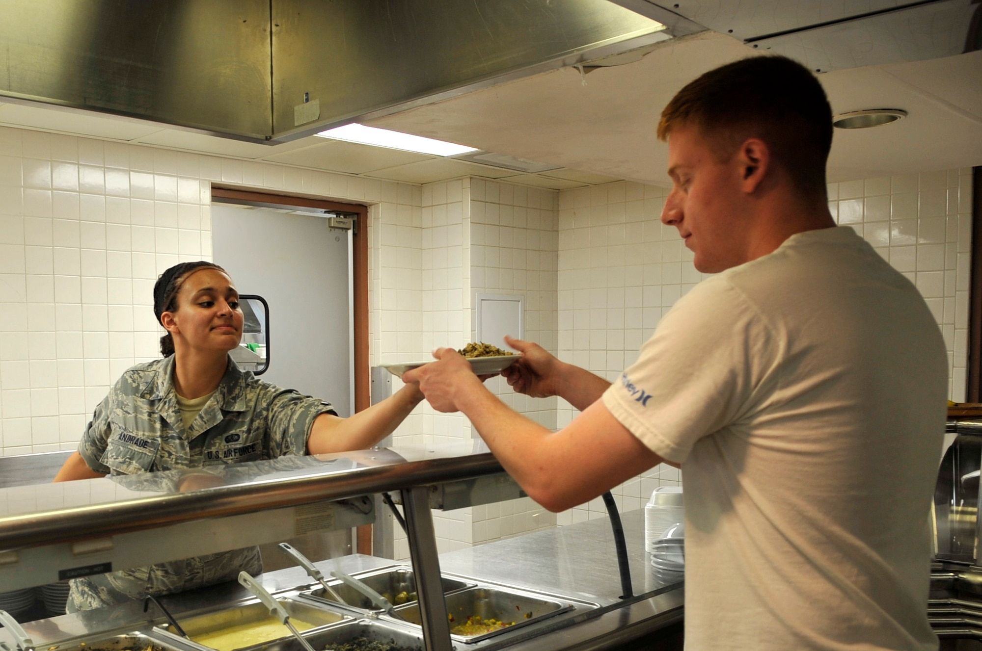 Senior Airman Christinajoy Andrade, food service specialist, serves a hot meal at the Red River Dining Facility on Barksdale Air Force Base, La., June 14, 2013. The dining facility serves four meals a day, seven days a week to anyone with base access. (U.S. Air Force photo/Airman 1st Class Benjamin Raughton)