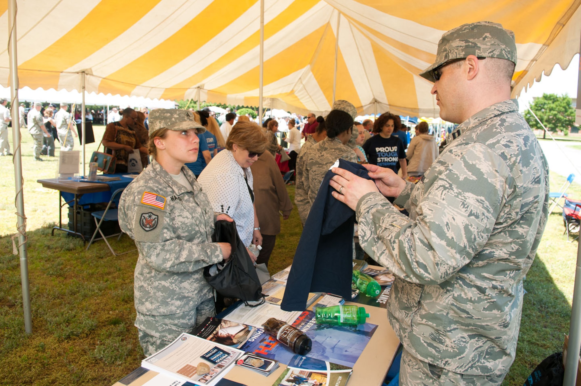 HANSCOM AIR FORCE BASE, Mass. -- Capt. Thomas Smith, from the Hanscom Mental Health clinic, hands out items during the Summer Buzz Expo encouraging servicemembers to get screened for post-traumatic stress disorder. The Mental Health clinic participated in several events throughout the week that highlighted PTSD Awareness Month. (U.S. Air Force photo by Rick Berry)