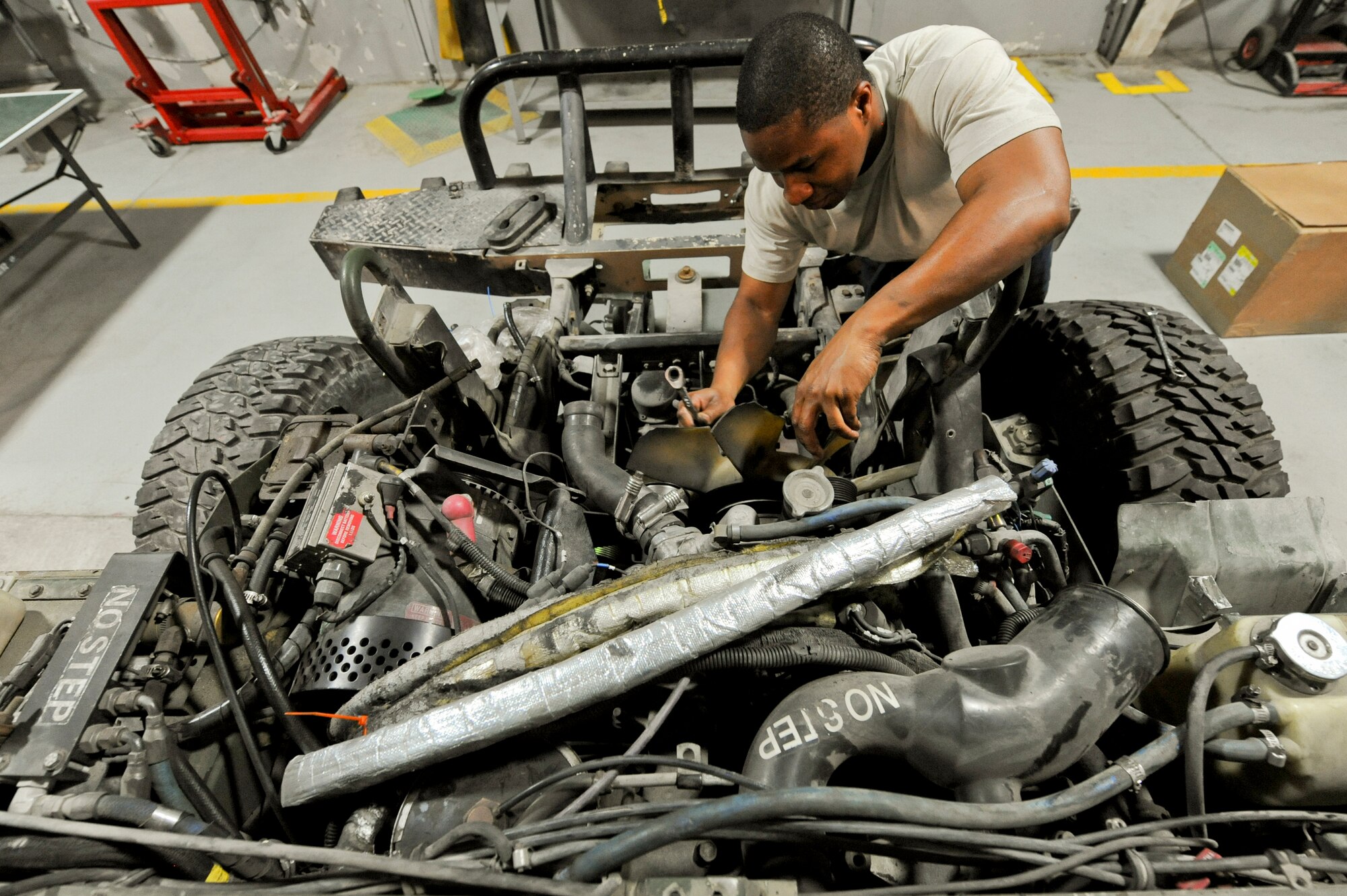 U.S. Air Force Staff Sgt. Steve Randall, 380th Expeditionary Logistics Squadron vehicle mechanic, removes a fan and fan clutch from a Humvee at an undisclosed location in Southwest Asia June 19, 2013. The vehicle maintenance shop is able to return vehicles back to service within 24 hours, depending on available parts. Randall is native to Kansas, Mo., and is deployed from Little Rock Air Force Base, Ar. (U.S. Air Force photo by Staff Sgt. Joshua J. Garcia)