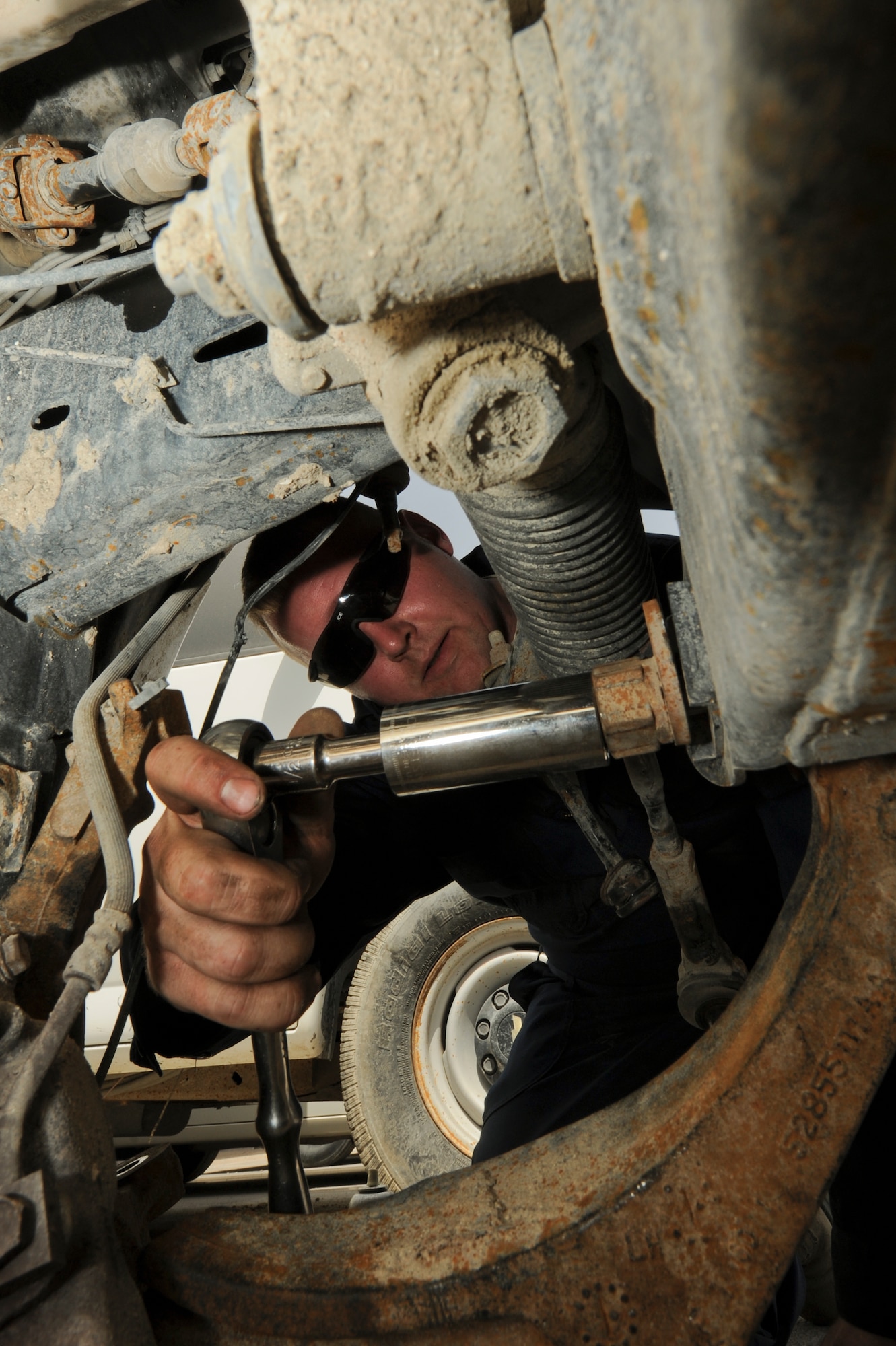 U.S. Air Force Staff Sgt. Martin Flora, 380th Expeditionary Logistics Squadron vehicle mechanic, removes a broken lower control arm from a vehicle at an undisclosed location in Southwest Asia June 19, 2013. The lower control arm is a pivot point for the vehicle’s suspension that holds the wheel and tire. Flora is native to Bemidji, Minn., and is deployed from Eielson Air Force Base, Alaska. (U.S. Air Force photo by Staff Sgt. Joshua J. Garcia)