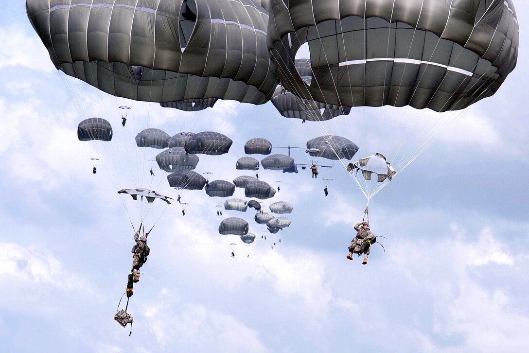 U.S. and Indonesian army paratroopers exit a C-17 Globemaster aircraft during a partnered mass-tactical airborne operation as part of exercise Garuda Shield 2013 bilateral training in West Java, Indonesia, June 18, 2013.
