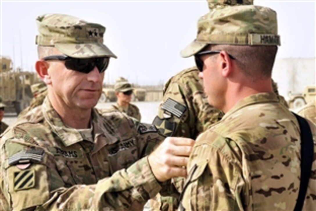 U.S. Army Maj. Gen. Robert "Abe" Abrams, commander of the 3rd Infantry Division and Regional Command, South, pins the Combat Action Badge onto U.S. Army Staff Sgt. Shane Hamann during a ceremony on Forward Operating Base Spin Boldak in Kandahar province, Afghanistan, June 19, 2013. Hamann, a public affairs specialist, is assigned to the 102nd Mobile Public Affairs Detachment. The Combat Action Badge is awarded to soldiers who are personally engaged by the enemy during combat operations.