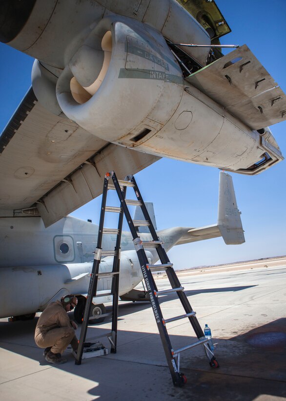 An MV-22B Osprey mechanic assigned to Marine Medium Tiltrotor Squadron (VMM) 266 (Reinforced), 26th Marine Expeditionary Unit (MEU), conducts routine maintenance on his aircraft at King Faisal Air Base in Jordan, June 14, 2013. Exercise Eager Lion 2013 is an annual, multinational exercise designed to strengthen military-to-military relationships and enhance security and stability in the region by responding to modern-day security scenarios. The 26th MEU is a Marine Air-Ground Task Force forward-deployed to the U.S. 5th Fleet area of responsibility aboard the Kearsarge Amphibious Ready Group serving as a sea-based, expeditionary crisis response force capable of conducting amphibious operations across the full range of military operations. (U.S. Marine Corps photograph by Sgt. Christopher Q. Stone, 26th MEU Combat Camera/Released)