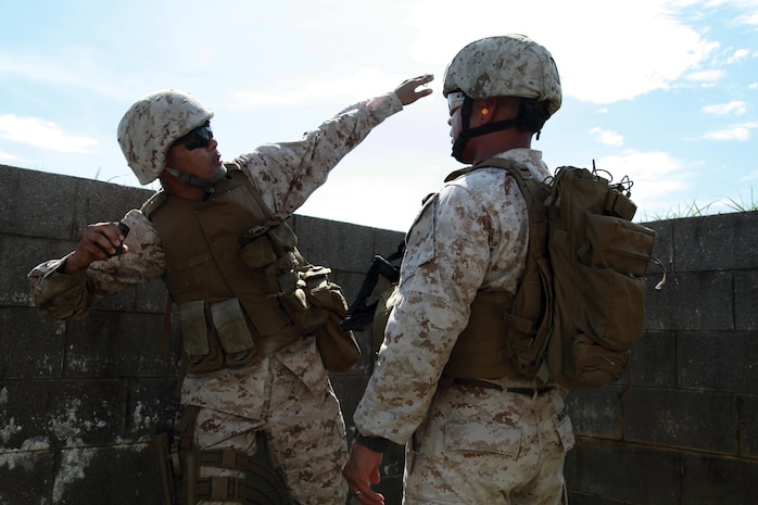 Gunnery Sgt. James W. Mackenzie observes Lance Cpl. Nam Q. Kim as he throws an M67 fragmentation grenade June 13 at Camp Hansen. Mackenzie is a tactics, readiness and training instructor, G-3, operations and training, 3rd Marine Logistics Group, III Marine Expeditionary Force, and Kim is an administrative clerk with CLR-35, 3rd MLG, III MEF.