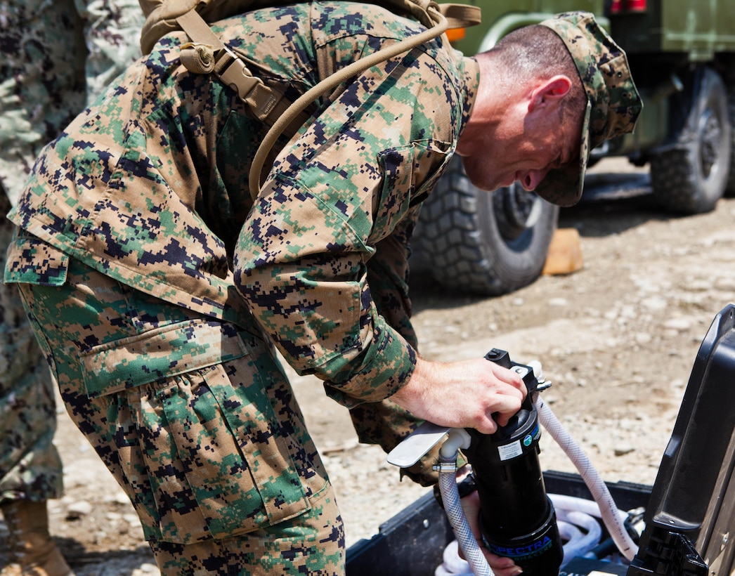 U.S. Marine Staff Sgt. John G. Bates III sets up a miniature deployable assistance water purification system during a demonstration at a disaster site in Biang, Brunei Darussalam, June 19 as part of the Association of Southeast Asian Nations Humanitarian Assistance/Disaster Relief and Military Medicine Exercise (AHMX). Engineers with China, Singapore and the U.S. demonstrated their water purification capabilities to senior leaders at the disaster site. Bates is a water support technician with 9th Engineer Support Battalion, 3rd Marine Logistics Group, III Marine Expeditionary Force.