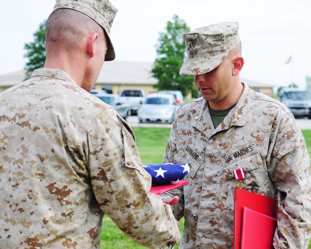 Maj. Christopher R. Barnard receives an American flag during a retirement ceremony, June 21. Barnard's most recent billet was assistant for officer procurement.