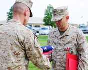 Maj. Christopher R. Barnard receives an American flag during a retirement ceremony, June 21. Barnard's most recent billet was assistant for officer procurement.