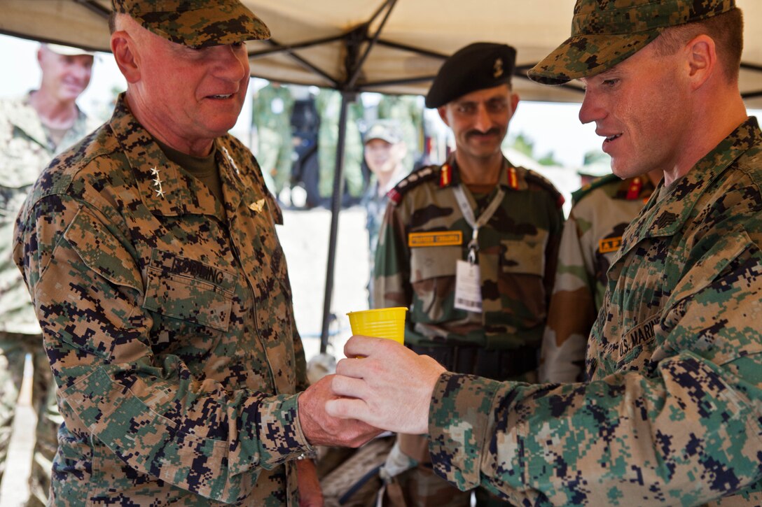 U.S. Marine Sgt. Robert W. Walker, right, provides a sample of purified water from the miniature deployable assistance water purification system to U.S. Marine Lt. Gen. Terry G. Robling at a disaster site in Biang, Brunei Darussalam, June 19 as part of the Association of Southeast Asian Nations Humanitarian Assistance/Disaster Relief and Military Medicine Exercise (AHMX). The disaster site is the location of the field training exercise portion of the multilateral exercise, which provides a platform for regional partner nations to address shared security challenges, strengthen defense cooperation, enhance interoperability and promote stability in the region. Robling is the commanding general of U.S. Marine Corps Forces, Pacific.  Walker is an engineer equipment electrical systems technician with 9th Engineer Support Battalion, 3rd Marine Logistics Group, III Marine Expeditionary Force.