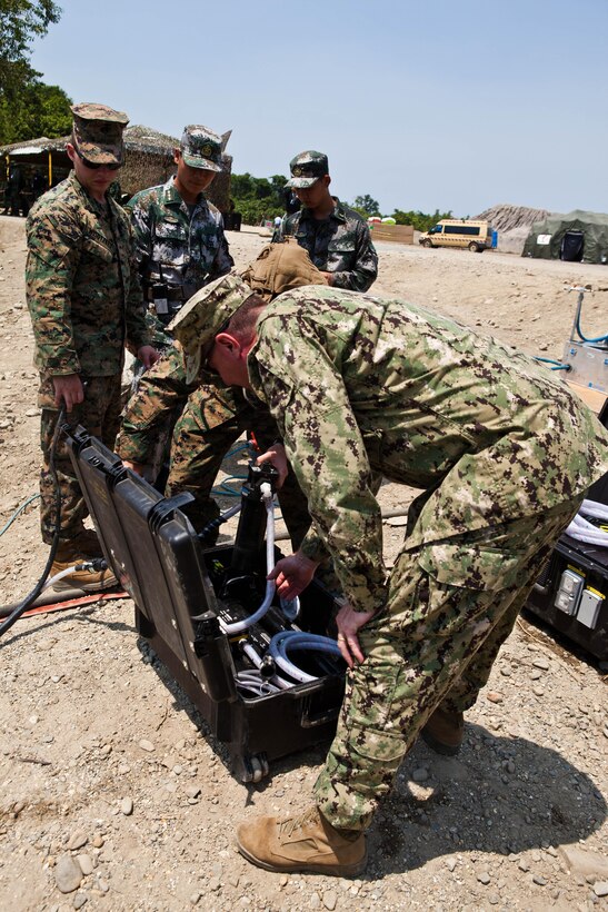 U.S. Marine and Navy engineers demonstrate the capabilities of the miniature deployable assistance water purification system at a disaster site in Biang, Brunei Darussalam, June 19 as part of the Association of Southeast Asian Nations Humanitarian Assistance/Disaster Relief and Military Medicine Exercise (AHMX). Engineers with China, Singapore and the U.S. demonstrated their water purification capabilities to senior leaders at the disaster site.