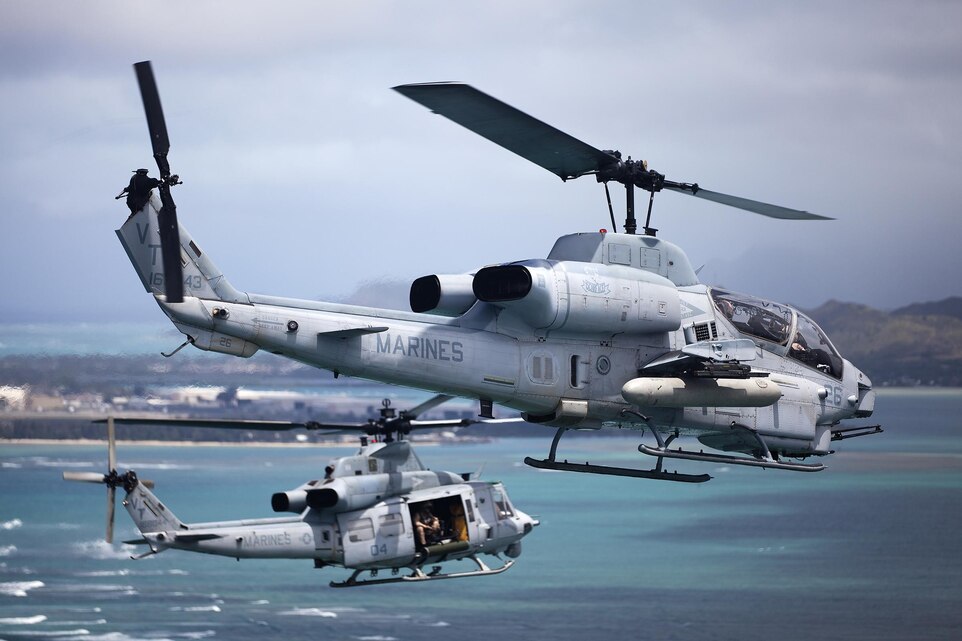 An AH-1W Super Cobra helicopter and UH-1Y Huey helicopter fly off the coast of the island of Oahu, toward Marine Corps Base Hawaii during maintenance and readiness flights, June 13, 2013. (U.S. Marine Corps photo by Sgt. Reece Lodder) 