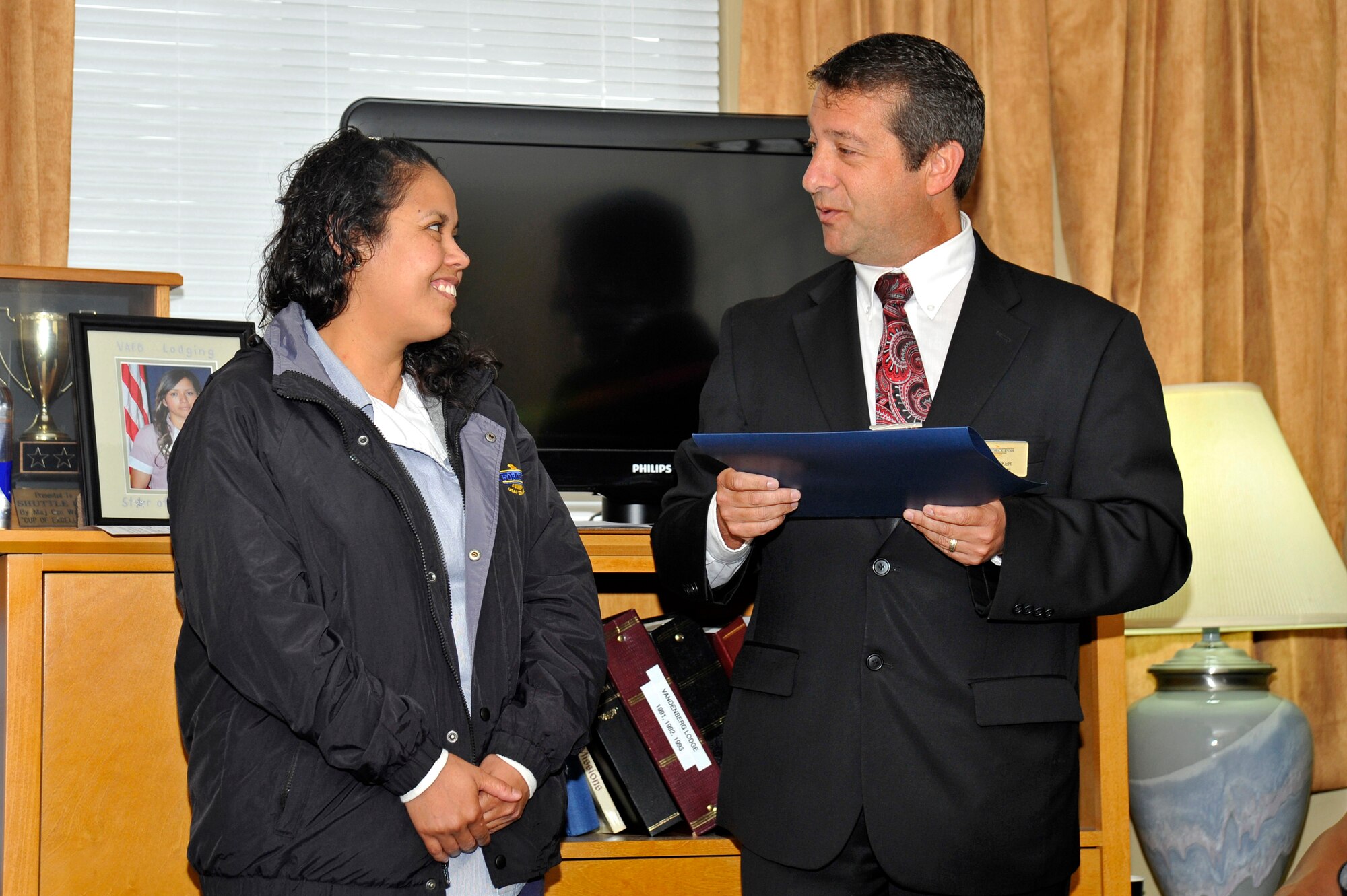 VANDENBERG AIR FORCE BASE, Calif. -- Daniel Becker, 30th Force Support Squadron lodging manager, presents Adriana Quintero, 30 FSS lodging housekeeper, with an on-the-spot cash award during a ceremony here Tuesday, Jun. 18. Quintero was honored for her heroic response in helping rescue a baby that choked on an object and stopped breathing. (U.S. Air Force photo/Michael Peterson)