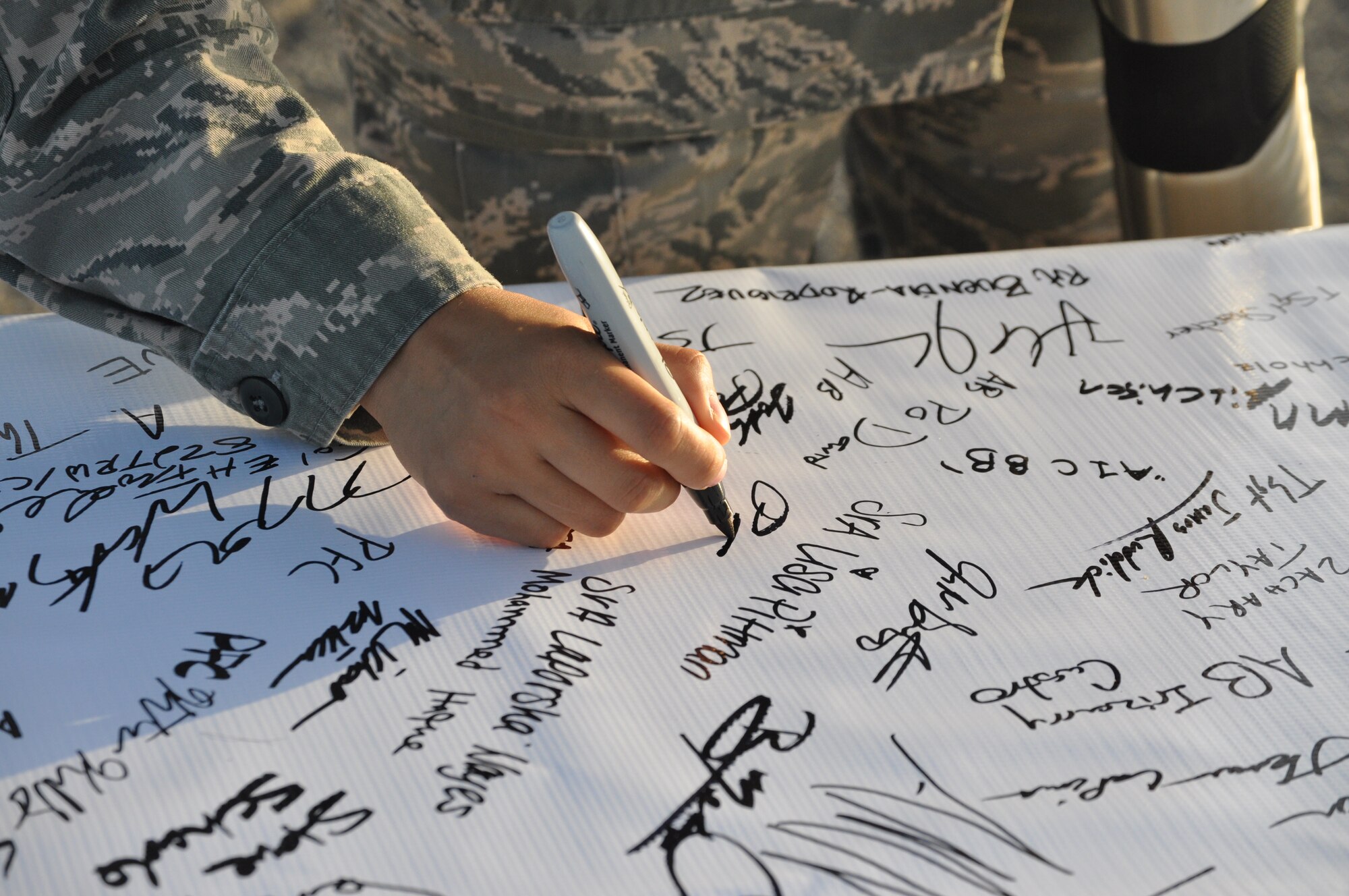 An Air Force member signs the banner representing Integrity during Operation REAL (Respect, Equality, Accountability, and Leadership) the event consisted of a base-wide stand down committed to eliminating sexual assault.. (U.S. Air Force photo by Kimberly Goff)