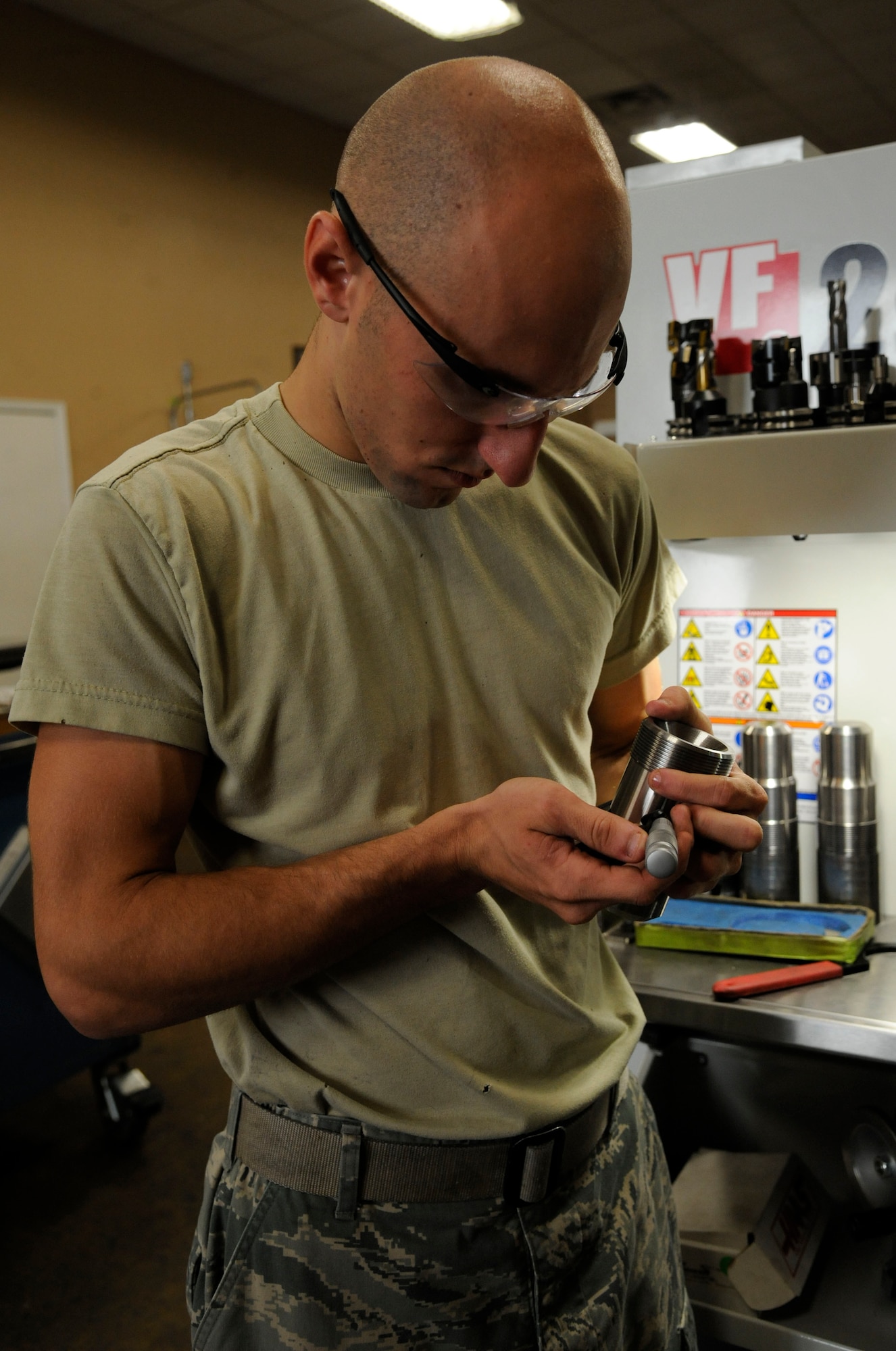 Senior Airman Jared Henden, from the 2nd Maintenance Squadron Fabrication Flight, inspects a finished sniper pod lug on Barksdale Air Force Base, La., June 20, 2013. After each lug is finished, it is inspected to ensure there are no discrepancies or imperfections. (U.S. Air Force photo/Airman 1st Class Andrew Moua)