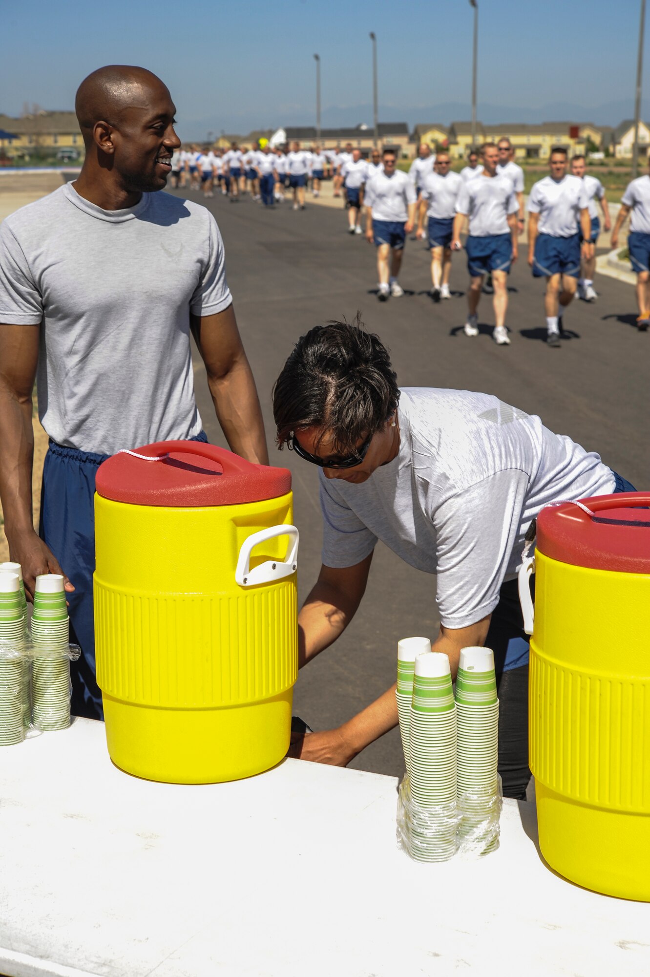 Chief Master Sgt.  Marilyn Savage, 460th Mission Support Group superintendent, right, takes a water break during a walk and talk June 20, 2013, on Buckley Air Force Base, Colo. Members of the 460th Space Wing took part in a Sexual Assault Prevention and Response stand-down day which focused on raising awareness and prevention measures for the increasing sexual assault problems facing the military today.  (U.S. Air Force photo by Staff Sgt. Christopher Gross/Released)