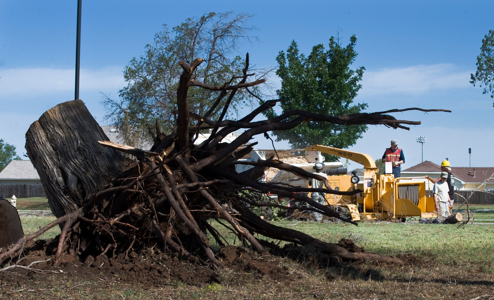 U.S. Air Force Airmen from the 7th Civil Engineer Squadron (CES) dispose of an uprooted tree after a storm subsided June 18, 2013, at Dyess Air Force Base, Texas. Due to the storm, there was loss of power to the base, downed trees, roof damage and broken windows. Repairs were quickly made by multiple 7th CES shops to include pavements and equipment, structures, water and fuel systems maintenance, electric, power production and heating, ventilation and air conditioning. (U.S. Air Force photo by Senior Airman Jonathan Stefanko/Released)