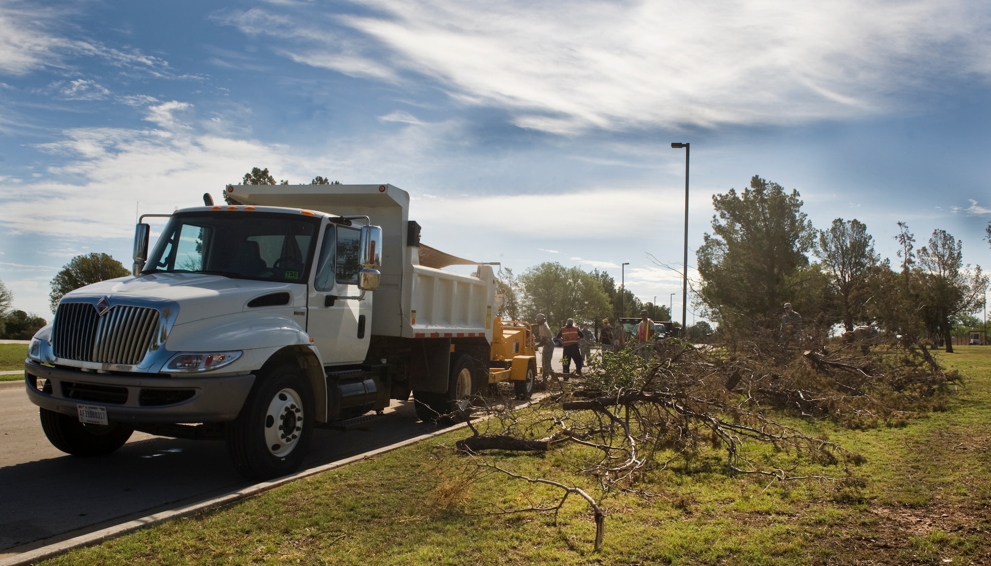 U.S. Air Force Airmen with the 7th Civil Engineer Squadron (CES) clean up tree debris June 18, 2013, at Dyess Air Force Base, Texas. The 7th CES pavements and equipment shop collected 65-tons of debris after a storm hit on June 17. (U.S. Air Force photo by Senior Airman Jonathan Stefanko/Released)