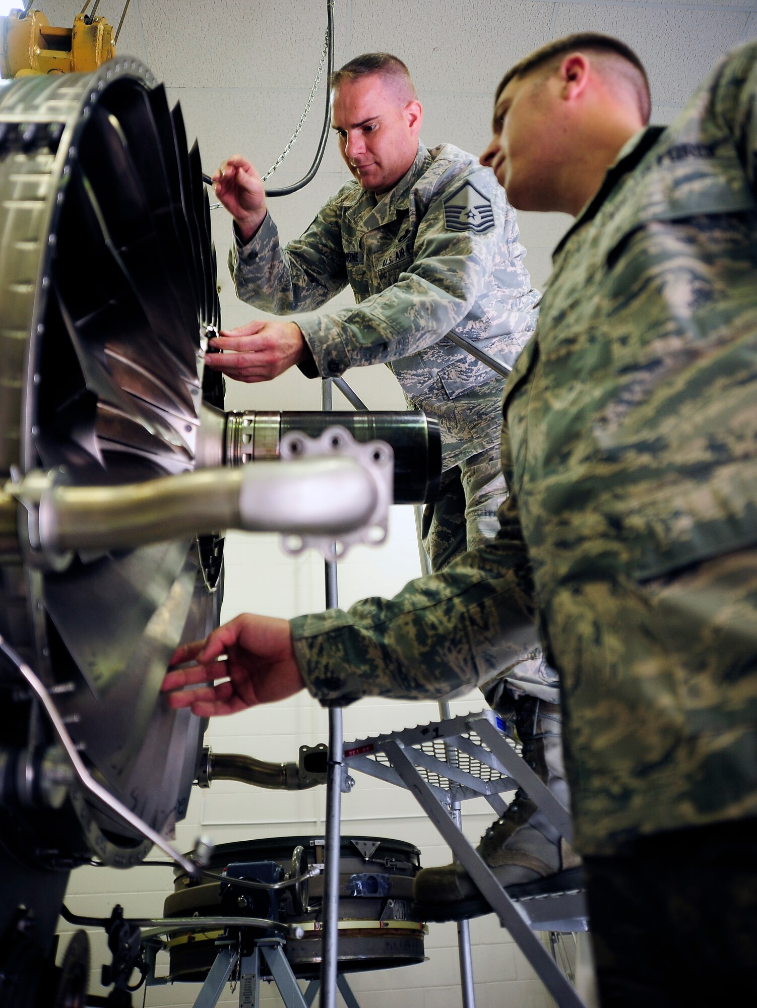 Master Sgt. James Boone, 372nd Training Squadron, Det. 6, production superintendent and propulsion instructor, gives hands-on engine help to Staff Sgt. Brandon Hysell of the 509th Maintenance Squadron propulsion shop during a basic propulsion class at Whiteman Air Force Base, Mo., June 14, 2013. Classes at the detachment range from just two to four students to make sure the instructors have time to give students this one-on-one attention. (U.S. Air Force photo by Staff Sgt. Brigitte N. Brantley/Released)