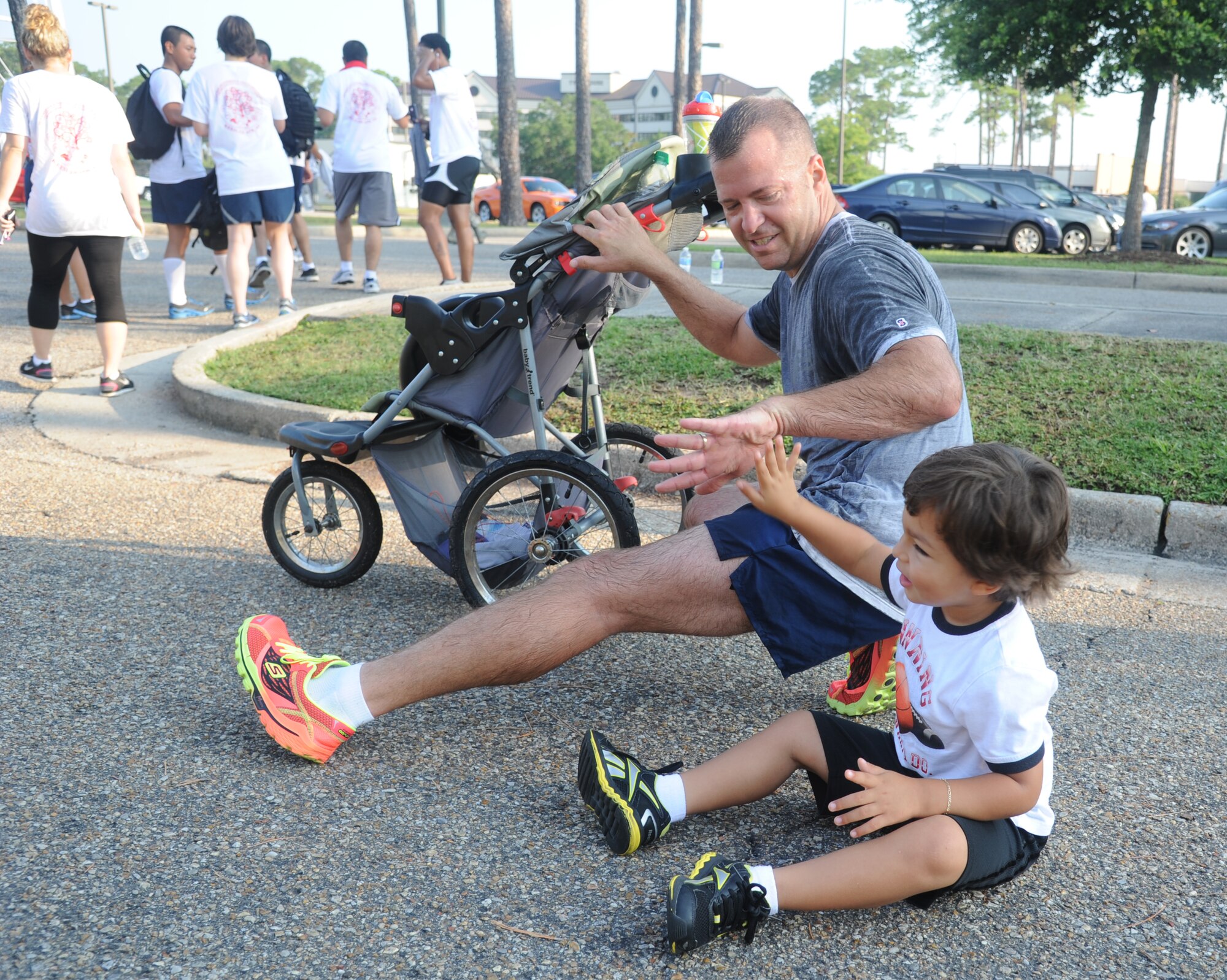Senior Master Sgt. Derek Fromenthal, 81st Training Support Squadron, and his son  stretch following a 5K run June 21, 2013, at Keesler Air Force Base, Miss., to show their support for Oklahoma tornado victims. More than 400 people pre-registered for the run and team Keesler raised more than $10,000 total to help aid in relief efforts.  (U.S. Air Force photo by Kemberly Groue)