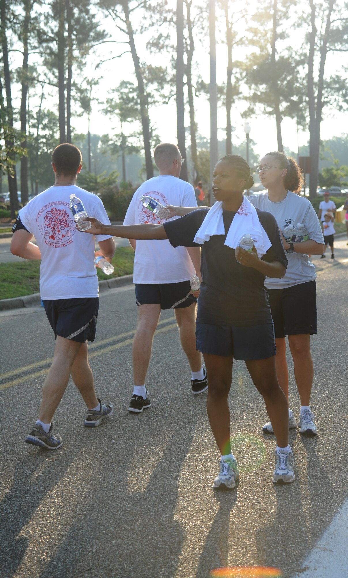 Tech. Sgt. Rickesia Tucker, Keesler NCO Academy, and Master Sgt. Christina Tinsley, 81st Dental Squadron,  provide waters to runners during a 5K run June 21, 2013, at Keesler Air Force Base, Miss., to show their support for Oklahoma tornado victims. More than 400 people pre-registered for the run and team Keesler raised more than $10,000 total to help aid in relief efforts.  (U.S. Air Force photo by Kemberly Groue)