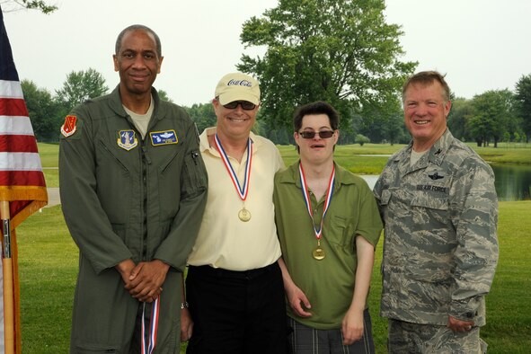Approximately 80 golfers-- Special Olympic Athletes, UNIFY Partners and parents -- were awarded with special coins and medals by  (left) Brig. Gen. Leonard Isabelle, Michigan assistant adjutant general for air, and  (right) Col. Michael Thomas, 127th Wing commander, at the end of a Special Olympics Michigan golf outing held at Selfridge Air National Guard Base, Mich., on June 21, 2013.  The event showcased the fact that many military families are becoming increasingly involved with the Special Olympics Michigan and UNIFY partner program, including Gary Shostak, former 927th Air Refueling Wing civil engineer, and his son, athlete Gary Jr.  (U.S. Air National Guard photo by John S. Swanson)
