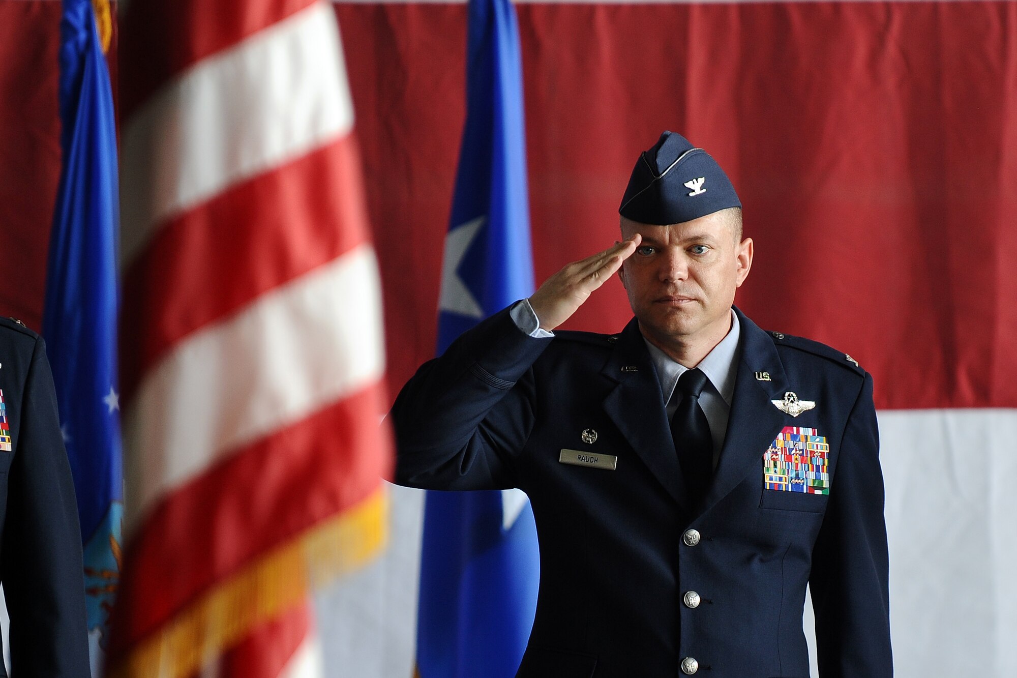 U.S. Air Force Col. John Rauch, 55th Wing commander, salutes the colors one last time as wing commander during the change of command ceremony held inside Dock 1of the Bennie Davis Maintenance Facility on June 19. Rauch relinquished command to U.S. Air Force Col. Gregory Guillot.  (U.S. Air Force photo by Josh Plueger/Released)