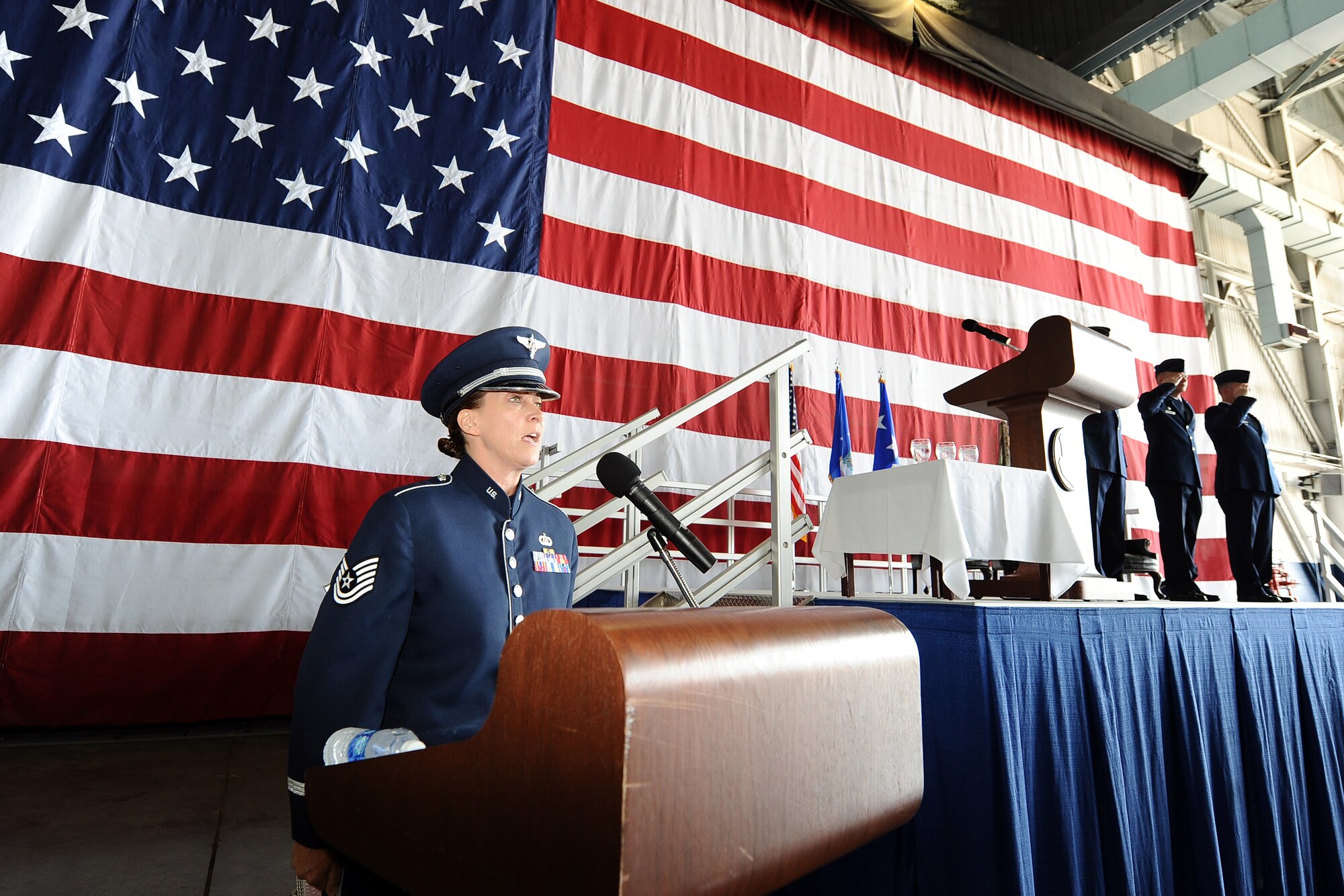U.S. Air Force Tech. Sgt. Rebecca Packard, a vocalist with the Heartland of America Band, sings the National Anthem to begin the 55th Wing change of command ceremony held in Dock 1 of the Bennie Davis Maintenance Facility on June 19, Offutt Air Force Base, Neb.  Airmen, family, friends and numerous distinguished visitors watched the military tradition of relinquishing and accepting command.  (U.S. Air Force photo by Josh Plueger/Released)