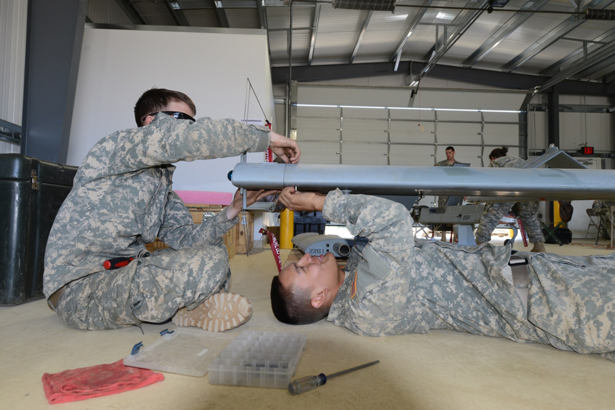 JOINT BASE ELMENDORF-RICHARDSON, Alaska -- Army Pvt. Derek Kistler and Army Pfc. Waziahta Long, both of 4th Brigade Combat Team (Airborne), 25th Infantry Division Brigade Bravo Company unmanned aerial vehicle maintainers, install a communication relay package onto a RQ-7 Shadow UAV during reconnaissance training at Forward Operating Base Sparta on Joint Base Elmendorf-Richardson June 11. The 4/25 Soldiers conduct this training to prepare for upcoming deployments and future training conducive to the JBER mission. (U.S. Air Force photo/Airman Ty-Rico Lea)