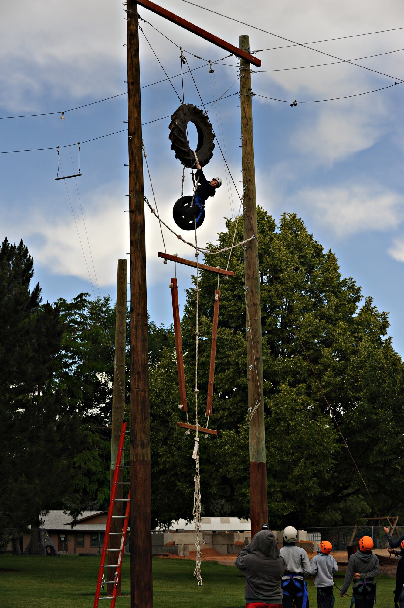 The group cheers on a fellow teammate as she battles to the top of a high element obstacle, June 19, 2013 at the College of Southern Idaho Challenge Course. Motivation and teamwork were two major tasks that had to be accomplished in order for the participants to reach their goals as a team. (U.S. Air Force photo by Airman 1st Class Brittany A. Chase/Released)