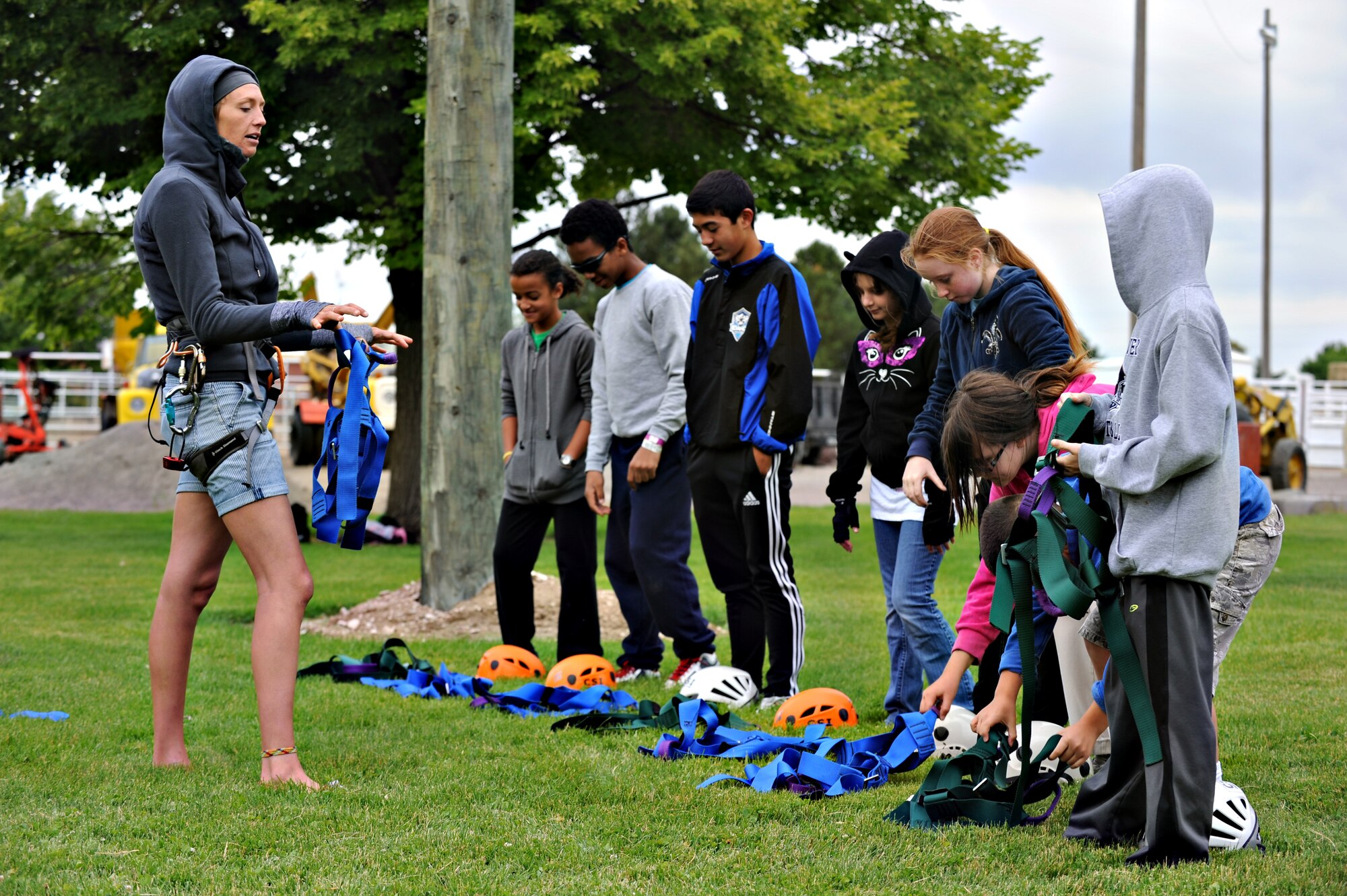 Christa Gessaman instructs Gunfighter children how to correctly put on their harness, June 19, 2013 at the College of Southern Idaho Challenge Course. The harnesses are implemented to keep participants safe at all times, while enjoying the course. (U.S. Air Force photo by Airman 1st Class Brittany A. Chase/Released)
