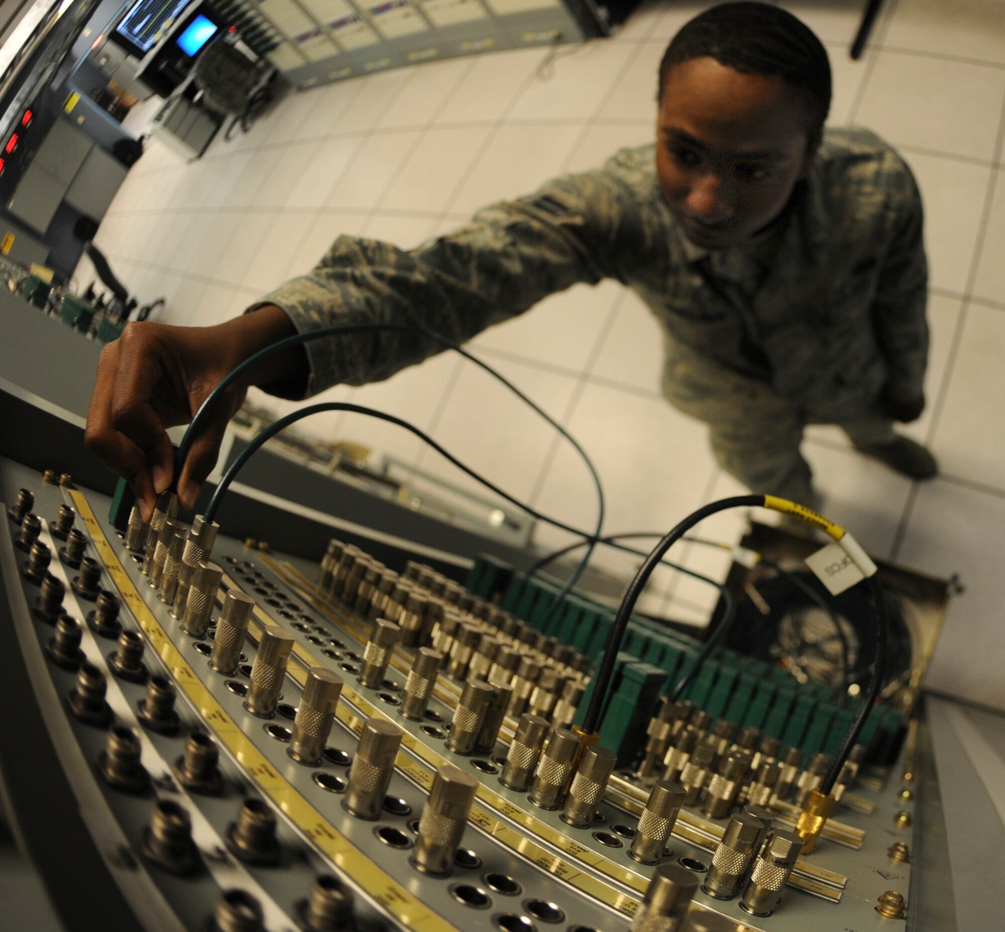 Airman 1st Class Andre Gallman, 6th Communications Squadron radio frequency apprentice, secures lines on a patch board May, 30, 2013, at MacDill Air Force Base, Fla. (U.S. Air Force photo by Senior Airman Michael Ellis/Released).