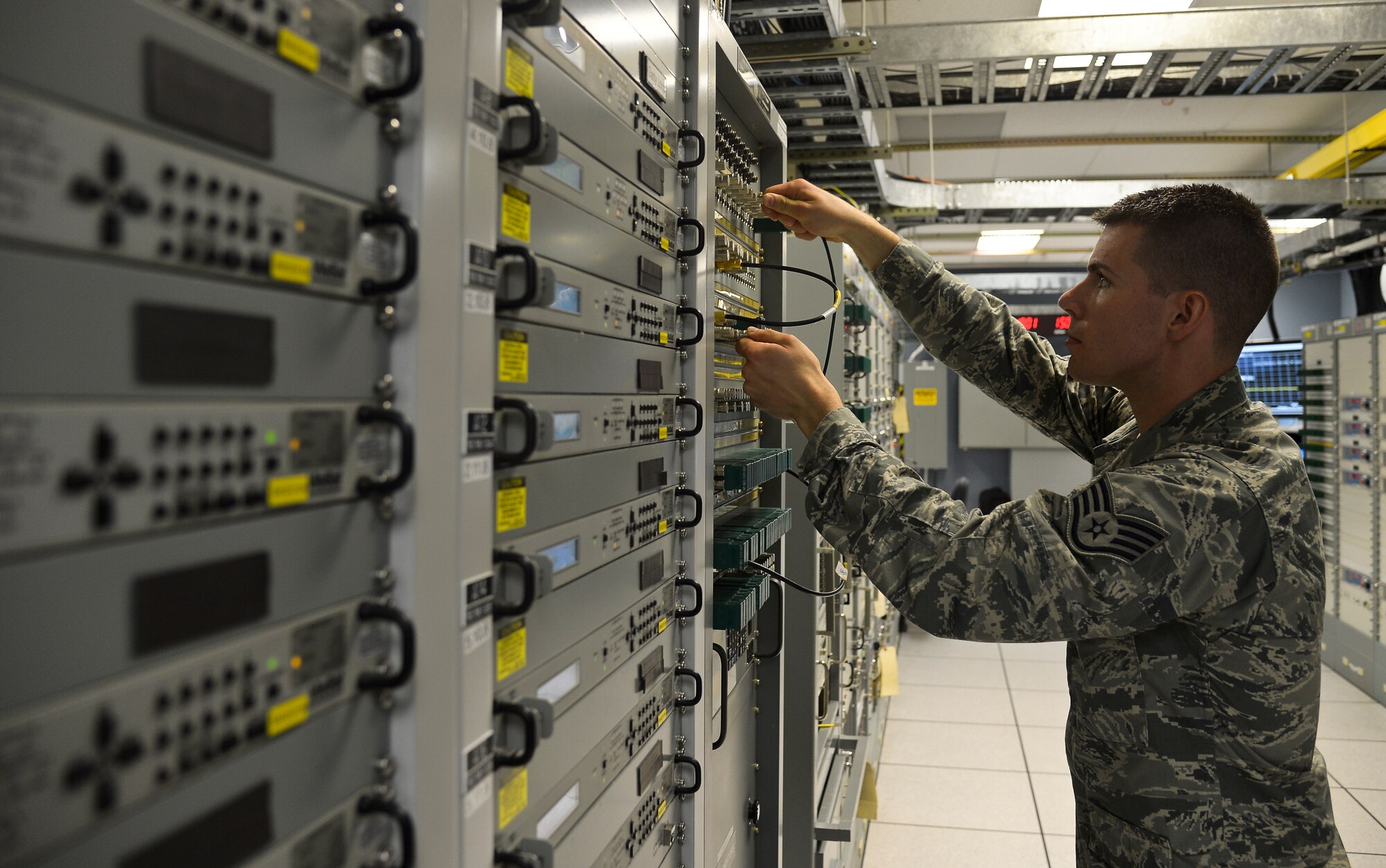 Staff Sgt. John Burns, 6th Communications Squadron radio frequency NCO inspects a stack of communications equipment used to send data signals from internal modulators, through patch panels, and to modems which hold the signal until pinged for transmission, May 30, 2013 at MacDill Air Force Base. (Photo by Staff Sgt. Brandon Shapiro