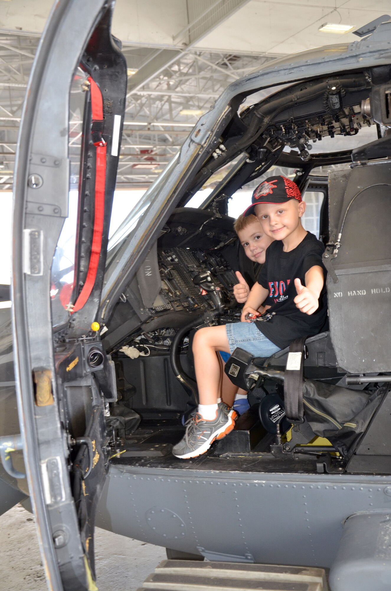 Trevor Scheerer, 5, and Finnian Gerts, 7, give a 'thumbs-up' while sitting in the cockpit of an HH-60G Pave Hawk rescue helicopter. The boys and their families visited the 920th Rescue Wing, Cocoa Beach, Fla., to learn about combat search and rescue and meet the rescue professionals. The boys are both battling cancer and met while in treatment at Arnold Palmer Hospital in Orlando, Fla. They were treated to a day they would never forget - tours of both rescue aircraft, the King and HH-60G Pave Hawk helicopters, and then finished with a "rescue mission" hosted by the pararescuemen here. (U.S. Air Force photo/2nd Lt. Leslie Forshaw)