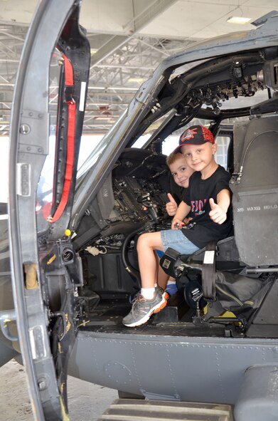 Trevor Scheerer, 5, and Finnian Gerts, 7, give a 'thumbs-up' while sitting in the cockpit of an HH-60G Pave Hawk rescue helicopter. (U.S. Air Force photo/2nd Lt. Leslie Forshaw) 

