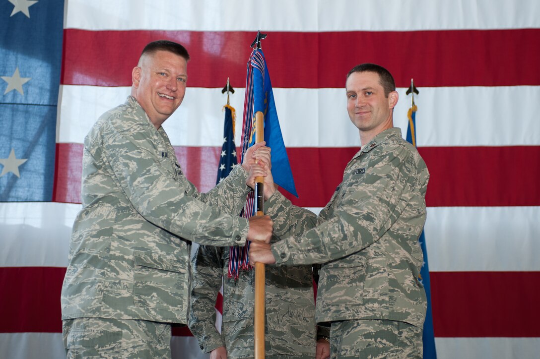 Col. James Katrenak (left), 28th Maintenance Group commander, presents the guidon of the 28th Munitions Squadron to Maj. Christopher Gardner, the new 28th MUNS commander, during a change of command ceremony at Ellsworth Air Force Base, S.D., June 20, 2013. Gardner, who comes to Ellsworth from Kirtland AFB, N.M., will command the 28th MUNS, whose mission is to provide conventional munitions, armament systems and trained munitions personnel to support the 28 combat-coded B-1 aircraft assigned to the 28th Bomb Wing. (U.S. Air Force photo by Airman 1st Class Alystria Maurer/Released)