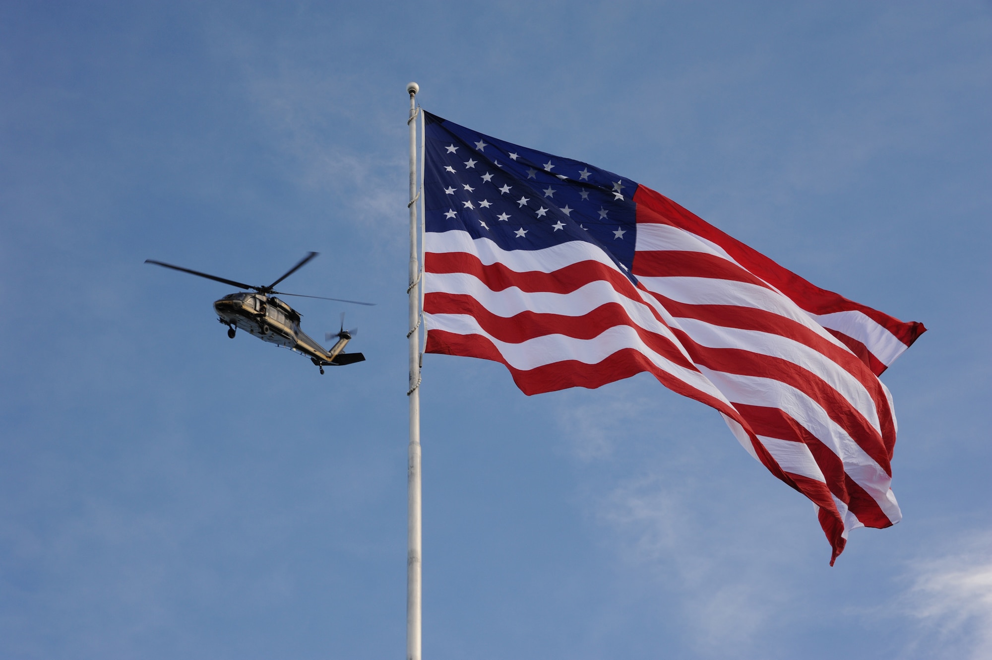 A Sikorsky UH-60 Black Hawk helicopter flies above to the American flag during  the 29th annual Flag Day ceremony at Broadwater Overlook Park in Great Falls on June 14. Those in attendence had a chance to see the 30-by-50-foot flag rise 110 feet. (U.S. Air Force photo/Senior Airman Katrina Heikkinen)